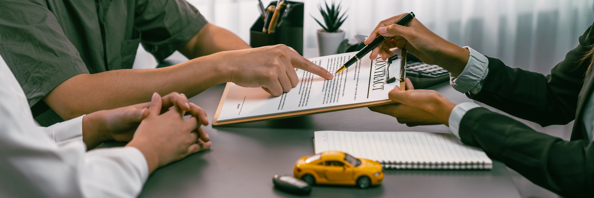 Car dealer calculate interest rate and costs of car loan, offering financial and insurance service while customer client reading on term and agreement on contract in dealership office. Prodigy